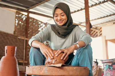 Portrait of young woman sitting on table