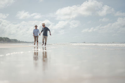 People at beach against sky