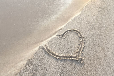 High angle view of heart shape on sand