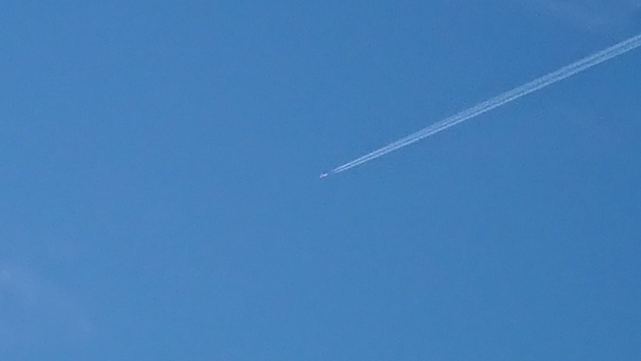 LOW ANGLE VIEW OF VAPOR TRAILS AGAINST CLEAR BLUE SKY