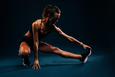 Side view of young woman exercising in gym