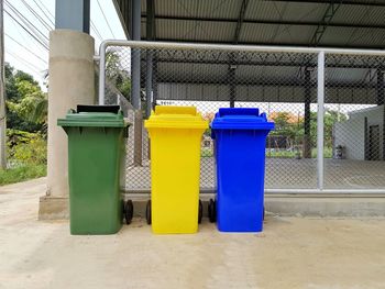 Multi colored garbage can against building