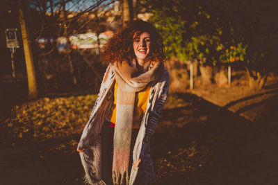 Portrait of smiling young woman standing outdoors during autumn