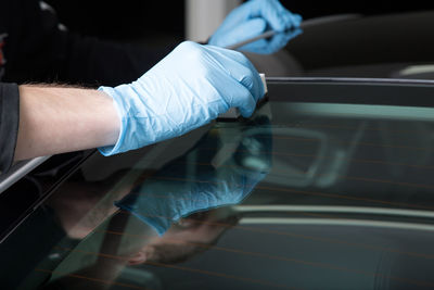 Midsection of man holding umbrella while sitting in car