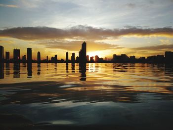 Silhouette buildings against sky during sunset