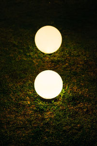 Close-up of illuminated light bulb in field