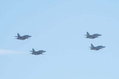 Low angle view of airplane flying against clear blue sky