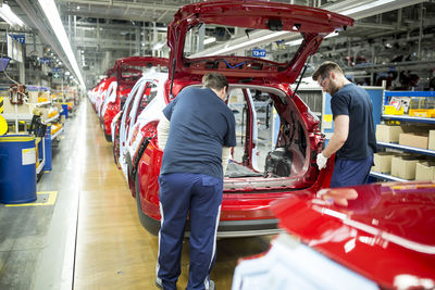 Two colleagues working in modern car factory