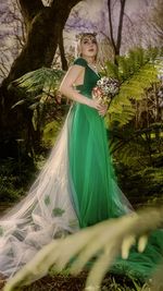 Portrait of woman standing by tree