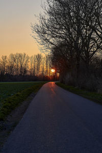 Empty road against sky during sunset