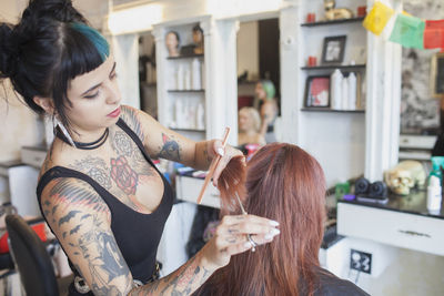 A hair dresser styling a customer's hair.