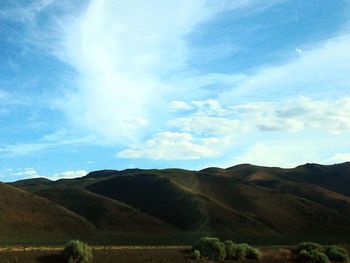 Scenic view of field and mountains against sky