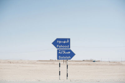 Signboards on desert against clear sky