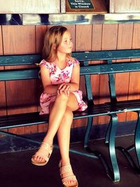 Girl sitting on bench while looking away