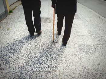 Low section of men walking on sidewalk