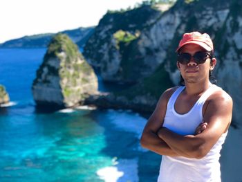 Portrait of man wearing sunglasses standing on rock