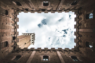 Directly below shot torre del mangia against sky