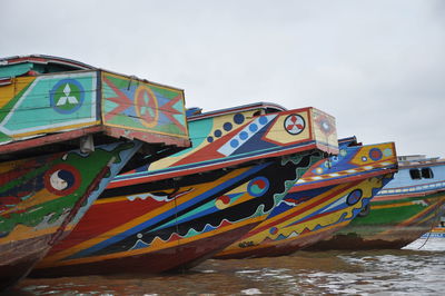 Multi colored boats moored on beach against sky