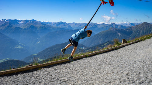 Boy playing against blue sky