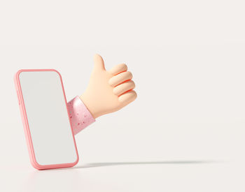 Close-up of hand holding smart phone over white background