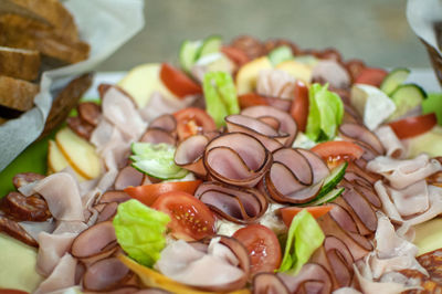 High angle view of chopped vegetables, ham and cheese on table