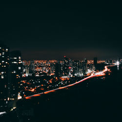 Illuminated cityscape against sky at night