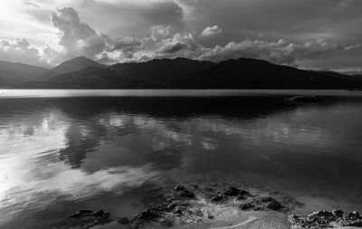 Scenic view of lake by mountains against sky