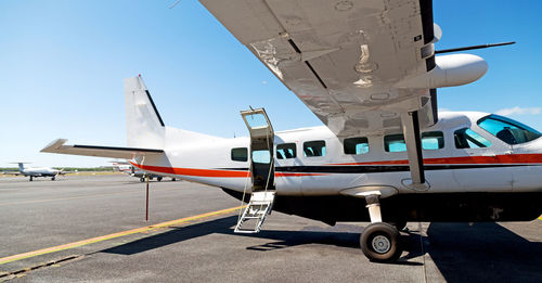 Airplane on airport runway against clear blue sky