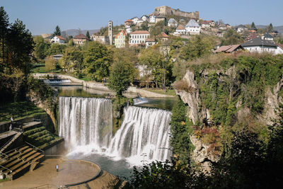 View of waterfall with buildings in background