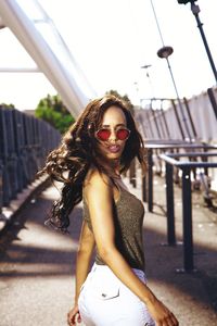 Portrait of young woman wearing sunglasses standing outdoors