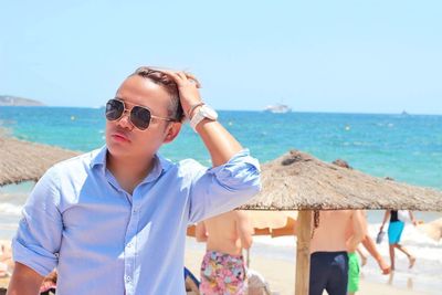 Man wearing sunglasses standing at beach