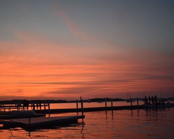 Silhouette pier over sea against sky during sunset