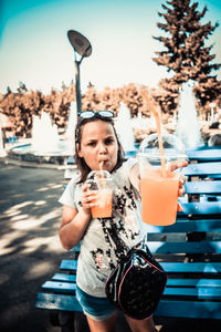 Portrait of young woman drinking glass