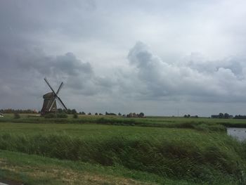 Windmill on field against sky