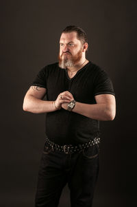 Midsection of man wearing mask against black background