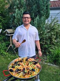 Portrait of smiling man standing against plants in yard