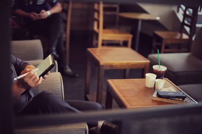 Midsection of man using digital tablet