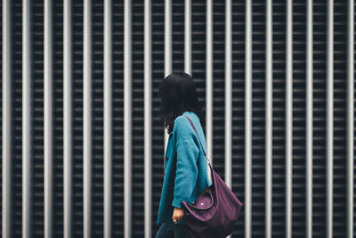 Woman walking against building