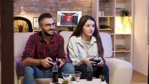 Smiling couple playing game at home