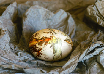 Variegated, painted and decorated easter egg on a background of crumpled paper