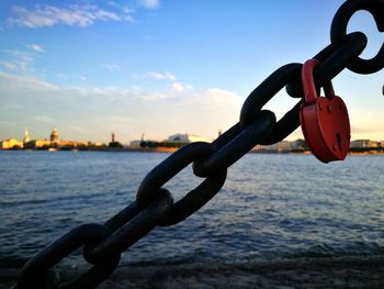 Close-up of padlocks on chain against river