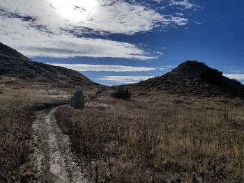 Scenic view of field and mountains against sky