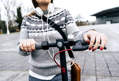 Close-up of young woman with electric scooter in the city