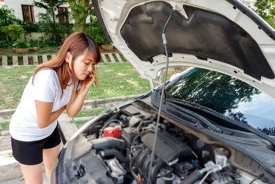 Full length of woman standing in car