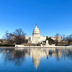 Reflection of us capital  in water against clear blue sky