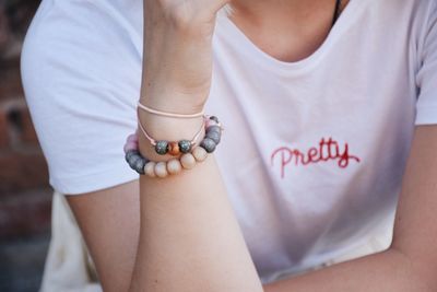 Midsection of woman wearing bead bracelet