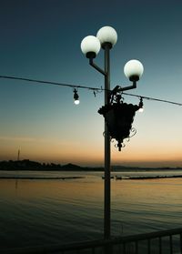 Street light by lake against clear sky