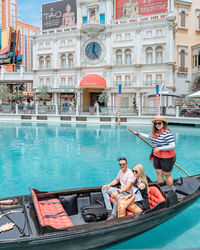 Young couple sitting on boat in canal