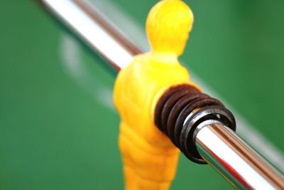 Close-up of yellow metal against wall