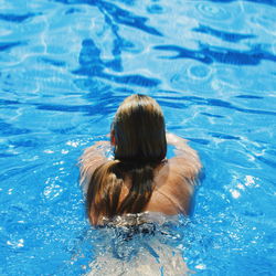 Rear view of woman swimming in pool